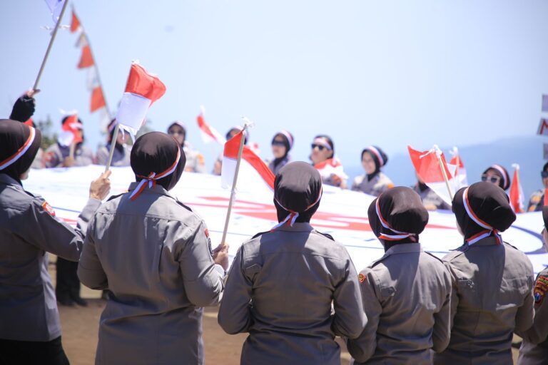 Hari Jadi ke-76, Polwan Polres Madiun Kibarkan Merah Putih dan Bendera Polwan di Puncak Bukit Mongkrang