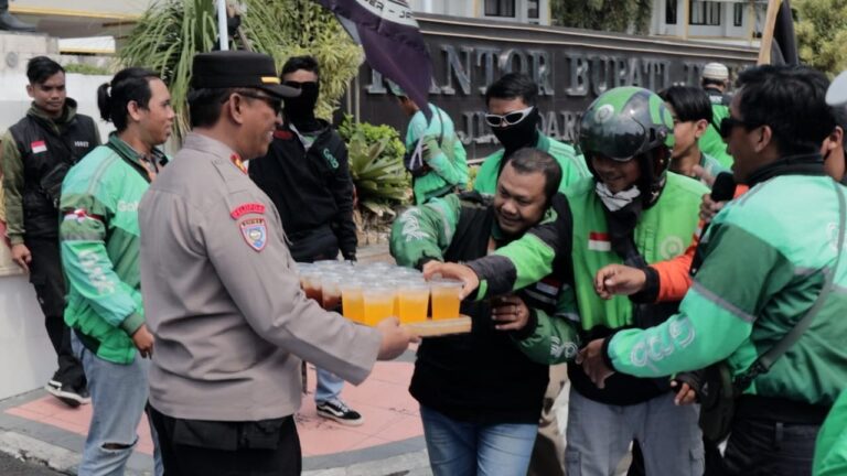 Humanis Polisi Kawal Aksi Damai Driver Ojol di Jember Sambil Berbagi Minuman Dingin