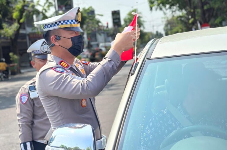 Semarak Jelang Hari Kemerdekaan RI ke-80, Polisi Berbagi Bendera Merah Putih di Nganjuk